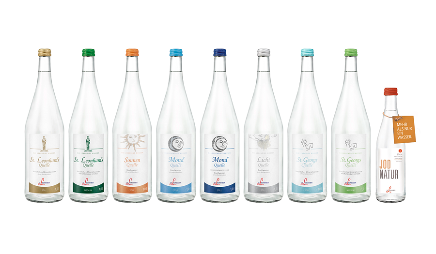 Mehrere Wasserflaschen, deren Etiketten minimalistisch, bunt designed sind.