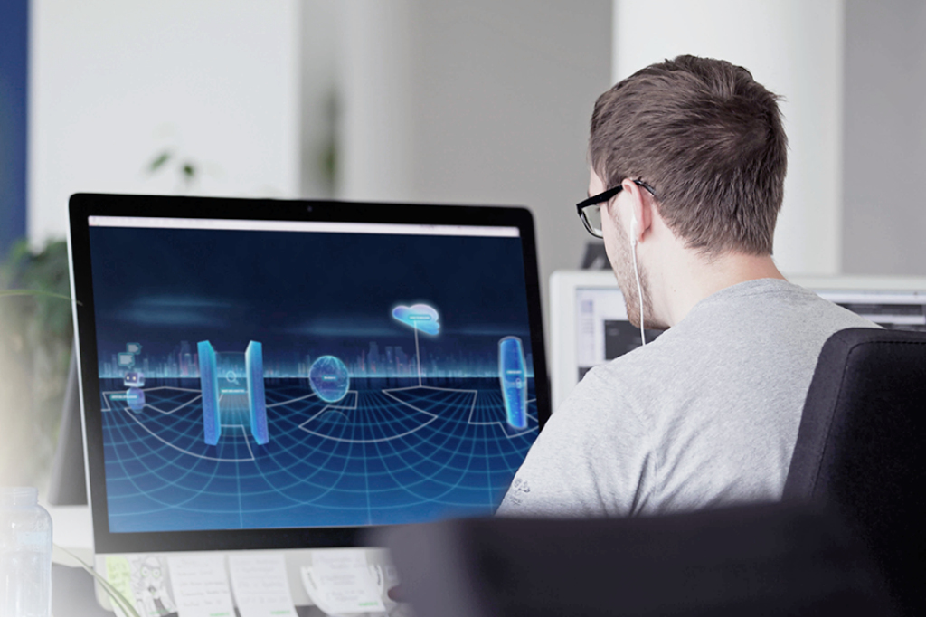 Foto eines Designers der vor einem Computerbildschirm sitzt und gerade an etwas arbeitet.