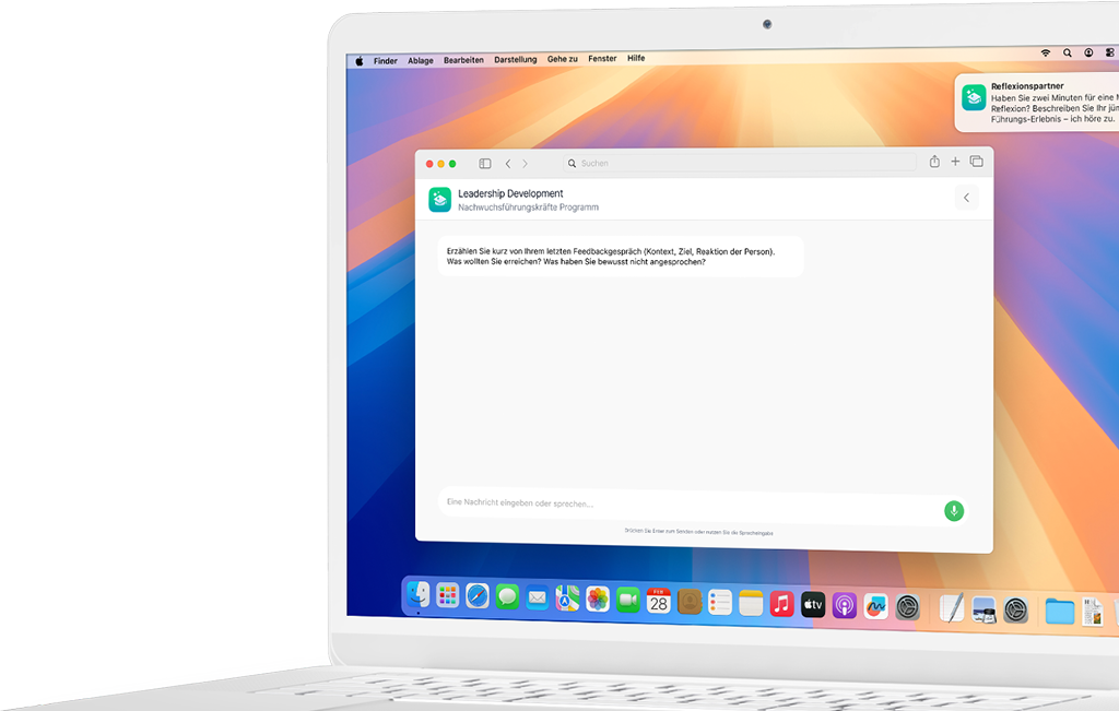 Laptop mit Chatfenster zum Thema Leadership-Entwicklung auf buntem Desktop-Hintergrund.